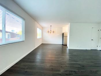 Spacious living room with large windows and hardwood flooring